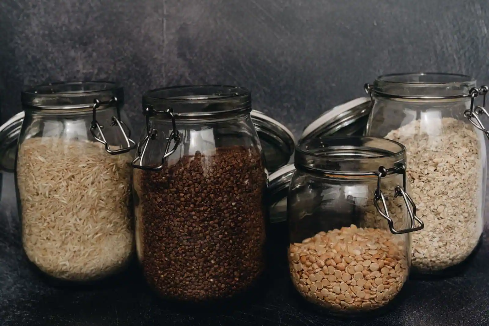 Bocaux en verre de céréales et légumineuses sèches : riz, sarrasin, pois cassés et flocons
