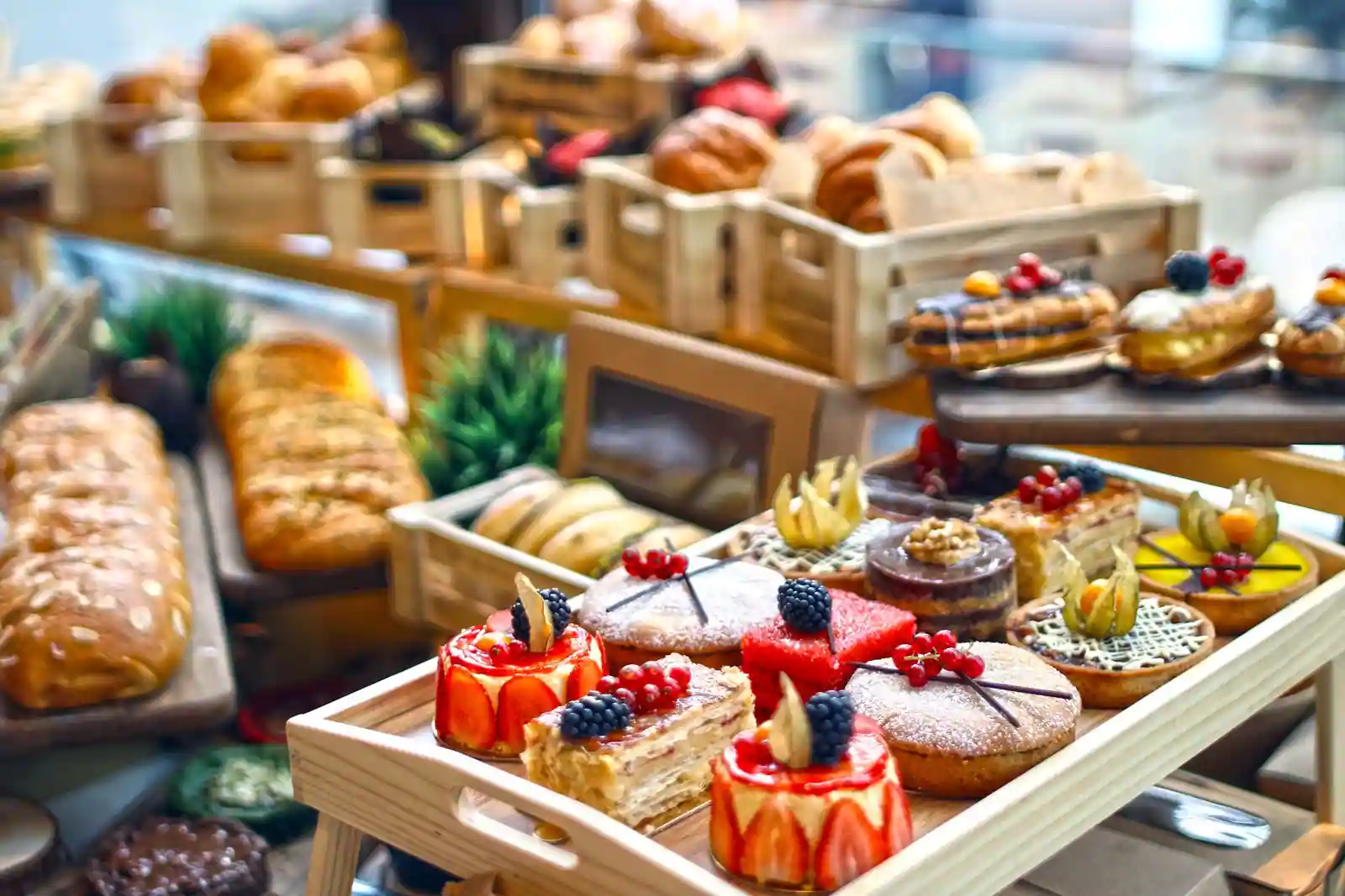 Assortiment de pâtisseries et desserts individuels — entremets aux fruits, tartelettes et mille-feuilles — présentés sur des plateaux
