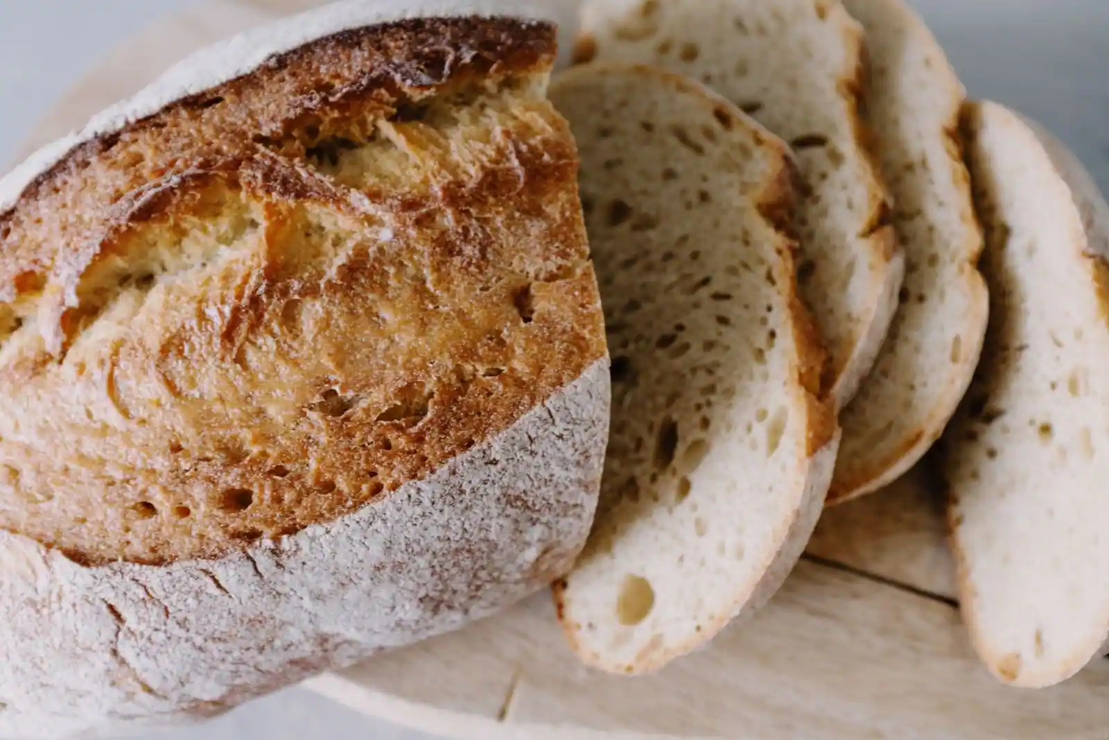 Boule de pain de campagne tranchée, posée sur une planche en bois