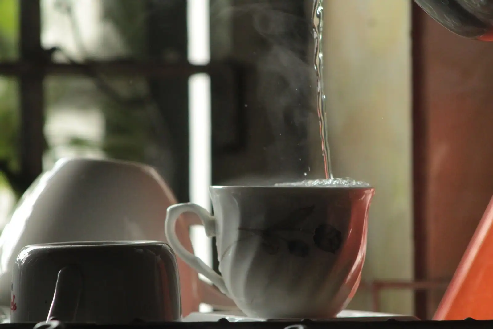 Eau chaude claire et fumante versée dans une tasse en porcelaine blanche, à l'image du café blanc