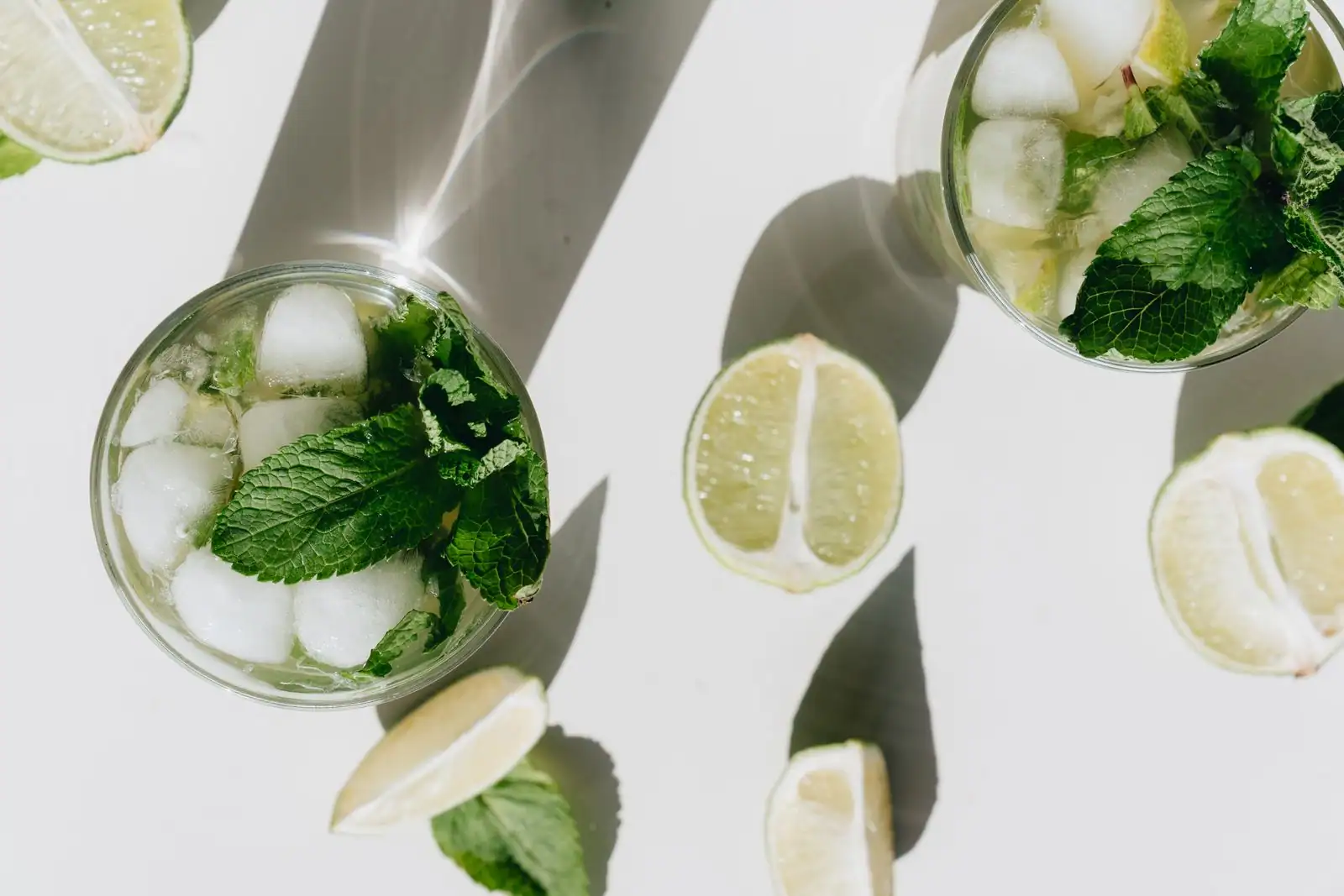 Cocktails pétillants glacés à la menthe fraîche et au citron vert, vus de dessus.