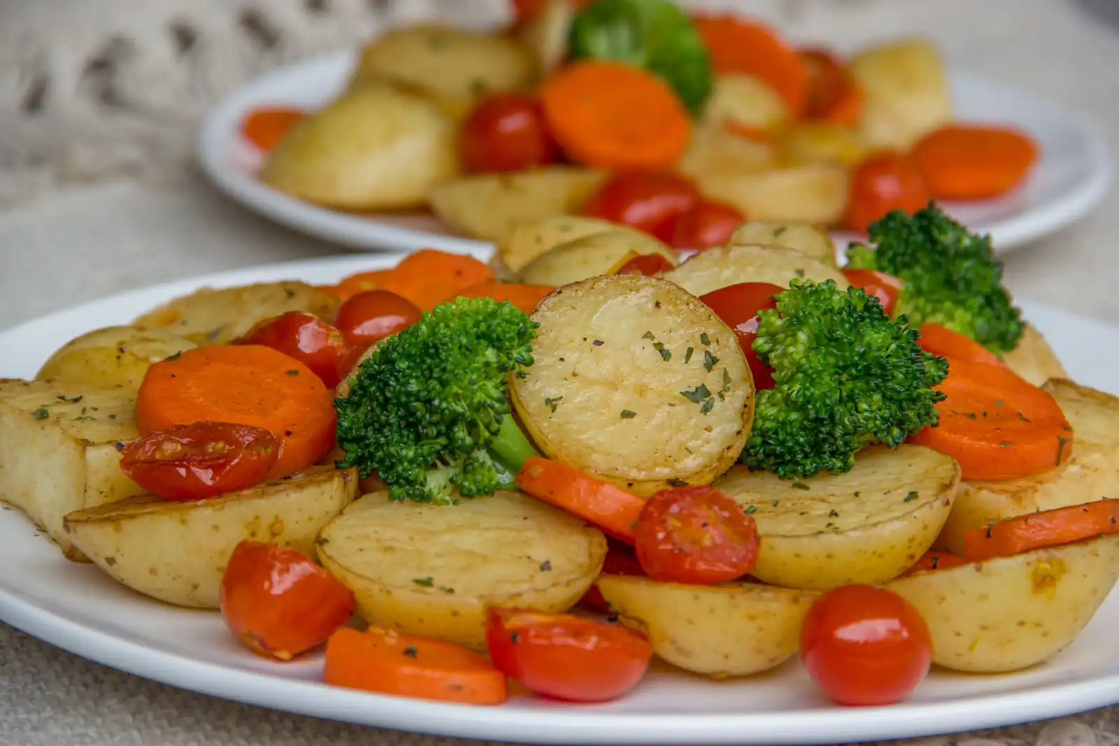 Assiettes de pommes de terre rôties avec carottes, brocolis et tomates cerises, un plat sans gluten.