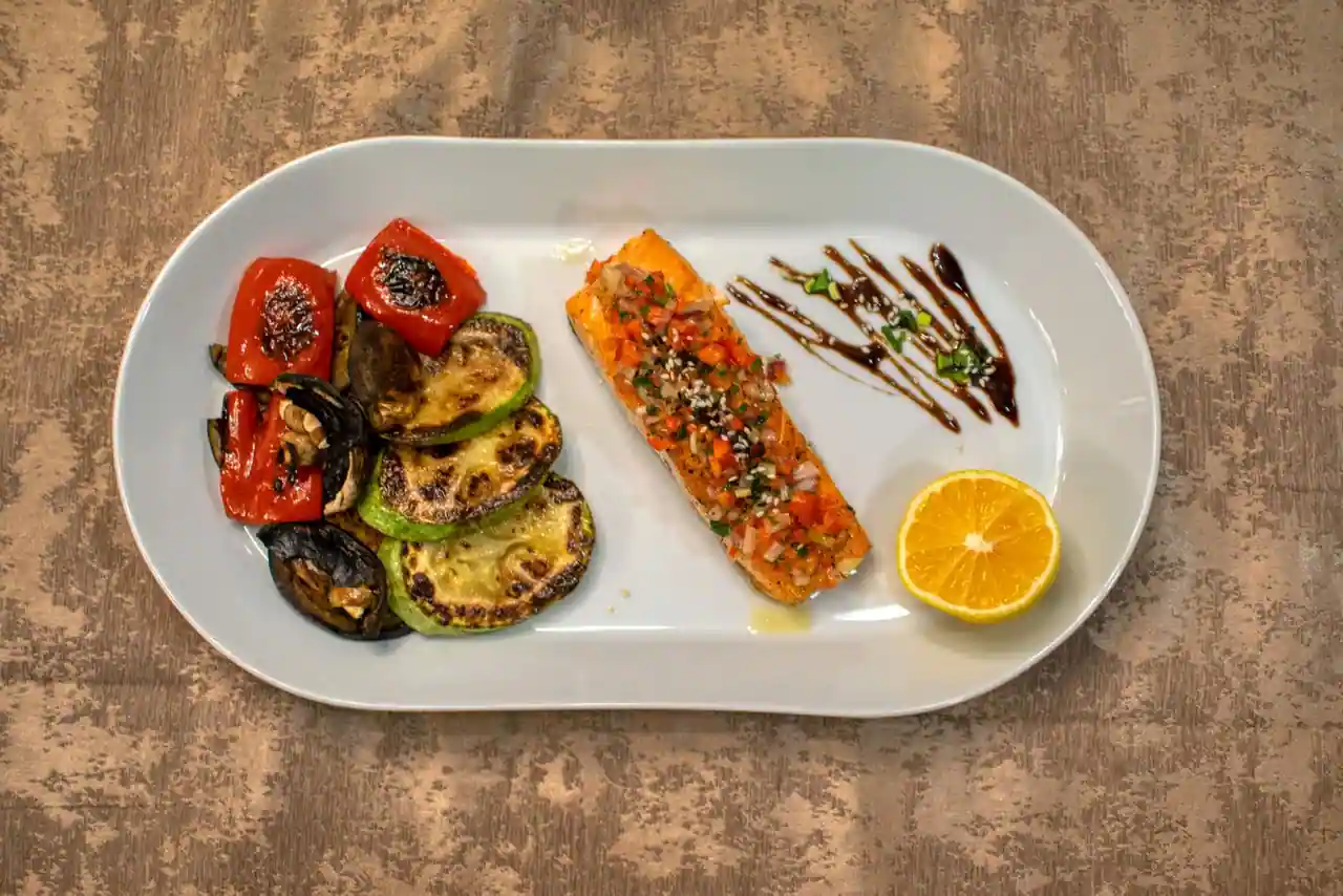 Assiette de saumon grillé accompagné de courgettes, aubergines et poivrons grillés, sans friture ni sauce crémeuse