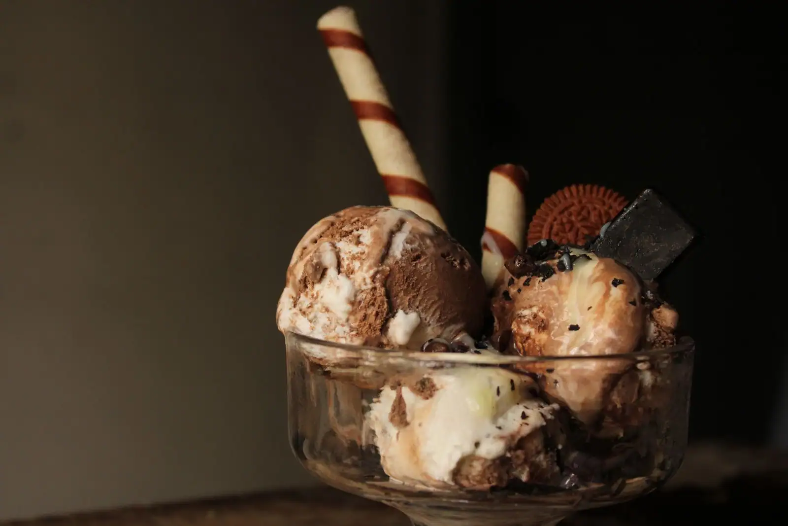 Coupe glacée façon sundae avec sauce chocolat et éclats croquants, dessert maison.
